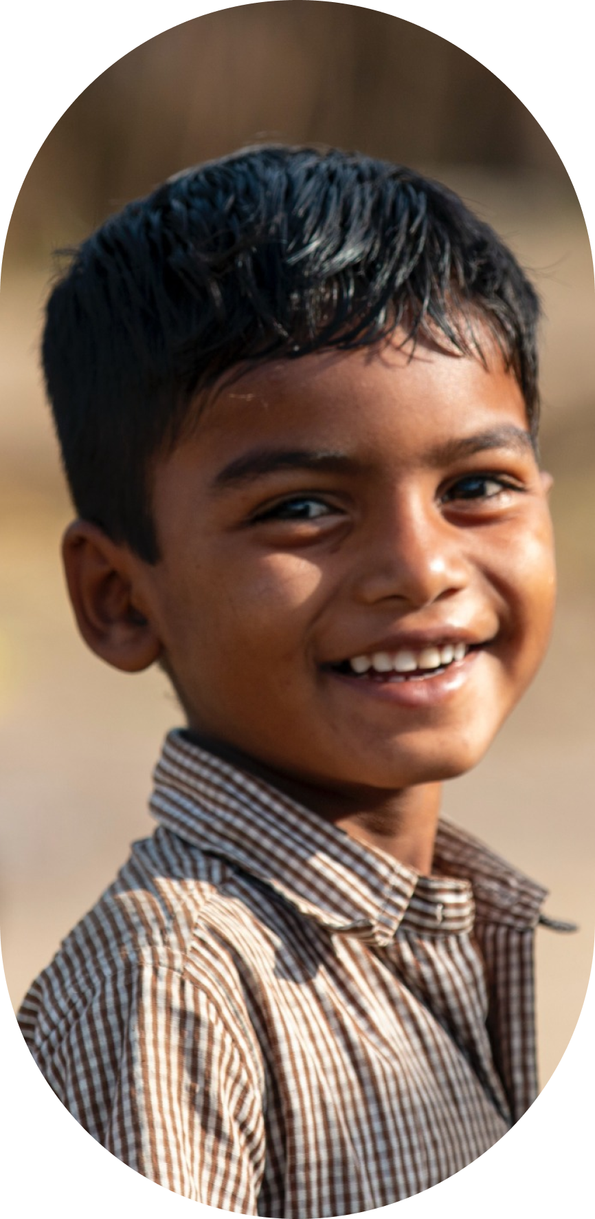 A little boy smiling in a black and white striped shirt
